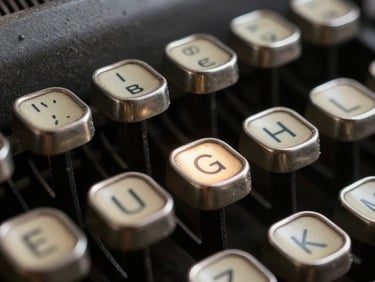 Macro shot of physical typewriter keys, dusty metal, single harsh light catching the letter G