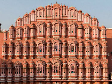The intricate pink facade of Hawa Mahal in Jaipur, warm low-angle sunlight casting soft shadows, elegant composition, 35mm