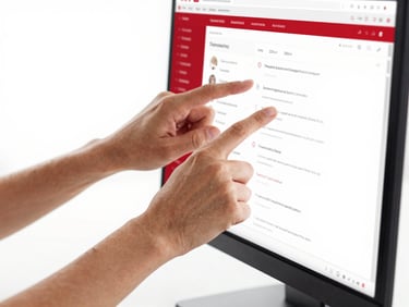Macro shot of a strategist's hands adjusting a digital ad campaign on a screen, clean modern workspace, bright high-key studio lighting, high-contrast red and white accents, sharp focus, 35mm lens.