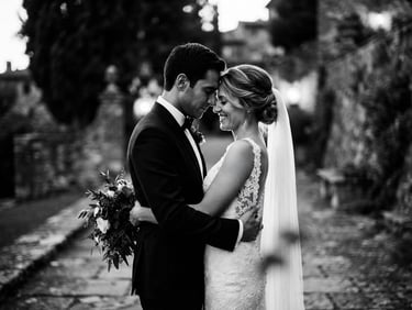 Dramatic emotional black-and-white wedding portrait, high-contrast cinematic lighting, shallow depth of field, 35mm anamorphic lens, elegant couple in quiet embrace