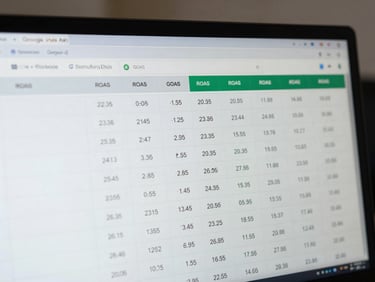 Tight crop of a Google Ads dashboard on a monitor, campaign ROAS column visible with specific numeric values, no people, cool neutral office lighting, slight depth of field blur on background