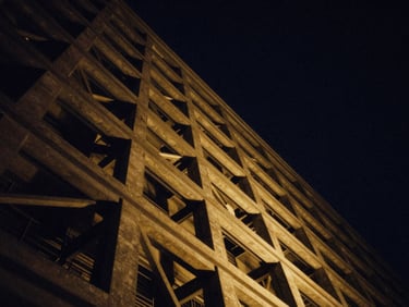 Abstract architectural lines reaching upward into a deep navy starry night, high-contrast golden light cutting through structural steel, 35mm cinematic editorial photography