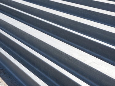 Uniones de acero estructural de alta precisión en una obra en construcción, con detalles de pernos y soldaduras, luz diurna brillante, sombras de alto contraste.