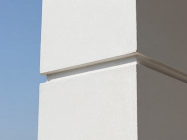 Close-up of a perfectly repaired and sanded drywall corner, smooth white plaster texture, clean lines, bright natural light, sharp focus, 35mm