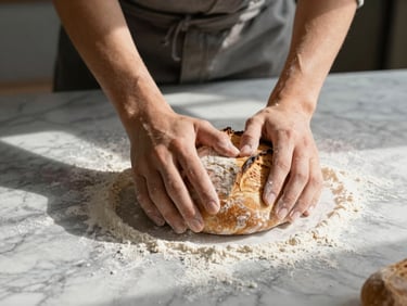 Landscape shot of hands kneading sourdough bread on a flour-dusted marble counter, soft morning light casting long shadows, warm tones.