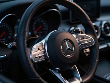 Close-up of a black Mercedes-Benz steering wheel with metallic trim, dramatic low-key night lighting