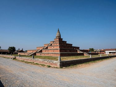 Structured plotting land in Bhaktapur with clear stone boundary markers, wide gravel access road, sunny day with deep blue sky.