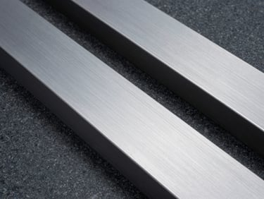 Abstract close-up texture of brushed steel and dark granite, clean architectural lines, cool overcast daylight, deep shadows