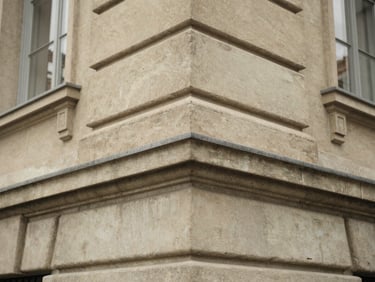 Macro detail of a classic limestone building corner in Geneva, soft overcast daylight, desaturated earth tones, architectural texture, 35mm
