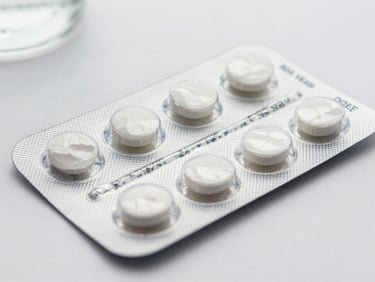 Close-up flat lay of a pharmaceutical blister pack on a white clinical surface, controlled studio lighting, sharp product labeling visible, neutral background