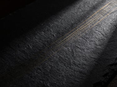 Abstract representation of data flows, subtle gold light lines on a dark textured slate background, low-key lighting, cinematic 35mm