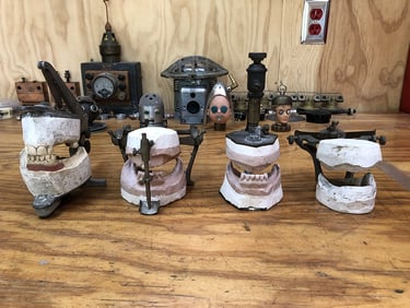 Four vintage dental phantoms on artist's workbench.