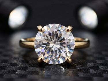 Extreme macro of a gold prong setting securing a brilliant moissanite stone under dramatic studio spotlights, 85mm lens