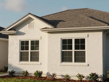 After photo of the same Florida residential exterior, fully re-stuccoed with smooth finish and new architectural foam trim at windows and roofline, natural afternoon daylight, no people, documentary framing