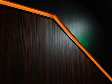 Close-up of premium acoustic fabric texture, micro-perforated wood paneling, dramatic low-key lighting with orange edge glow