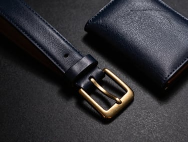 Close-up of an elegant flat-lay of a dark leather belt and matching wallet, dramatic side-shadows