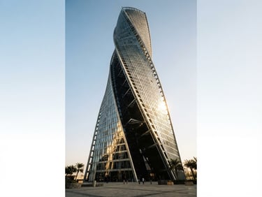 Low-angle heroic architectural shot of Abu Dhabi modern steel and glass tower facade, sharp early morning desert sun, long high-contrast shadows, 35mm lens