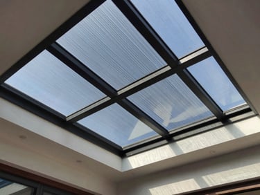A modern residential sunroom with solar control film applied to the glass ceiling, bright natural light, clear views