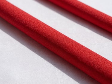 Close-up texture of high-quality red and white linen fabric, warm natural sunlight, professional studio lighting