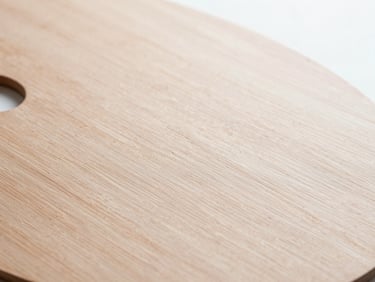 Oil paint mixing on a wooden palette, close-up texture, bright natural north-facing daylight, sharp focus, 35mm