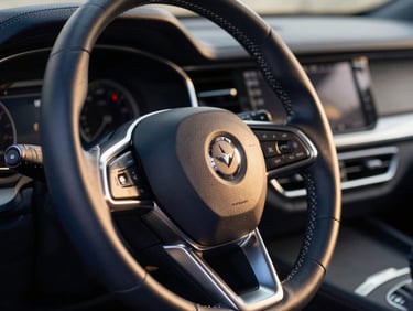 Close-up of a high-end car leather steering wheel and refined dashboard stitching, soft golden-hour light reflecting on polished metallic details, elegant automotive photography, 50mm, sharp focus