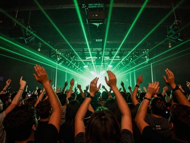 Wide-angle crowd shot from the stage perspective, hands raised under moody green lasers, raw concert energy
