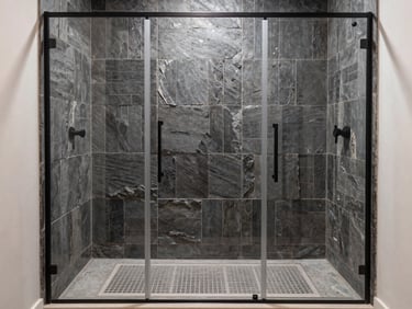 Straight-on architectural photo of a modern walk-in shower with vertical stacked dark slate tiles, perfect grout alignment, matte black hardware, bright natural light.