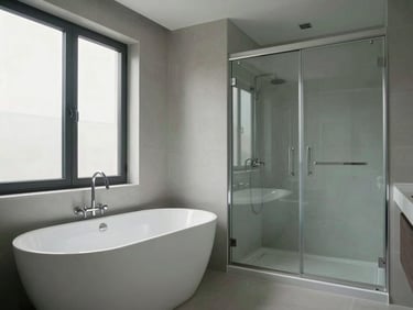 Wide architectural shot of a complete bathroom installation: freestanding bathtub, wall-mounted faucet, and glass shower enclosure in situ, cool north-facing daylight, empty room showing scale and system coordination