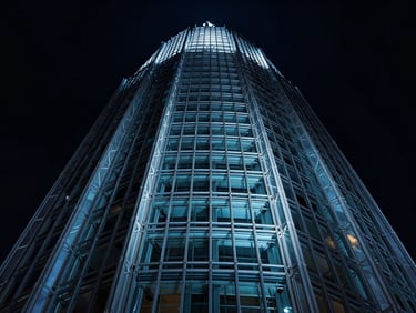 Dramatic low-angle shot of a glass and steel tower crown, structural wireframe lines reflecting cool blue light, deep shadows, 35mm lens