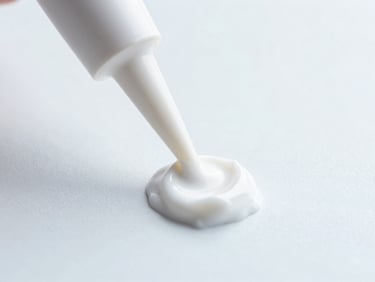 Macro shot of white cosmetic cream texture being extruded from a laboratory pipette, clean clinical photography, high-key lighting, 35mm