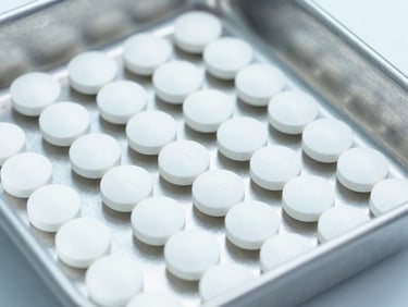 Close-up of clean, organized veterinary supplement tablets on a sterile stainless steel laboratory tray, bright cool lighting, 35mm