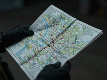 Close-up of hands wearing dark gloves, holding a tactical map with route planning, low-key lighting, cinematic, sharp focus