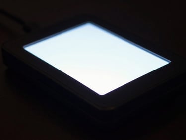 Tight macro shot of a secure communication device on a dark surface, glowing screen, low-key lighting, cinematic, sharp focus