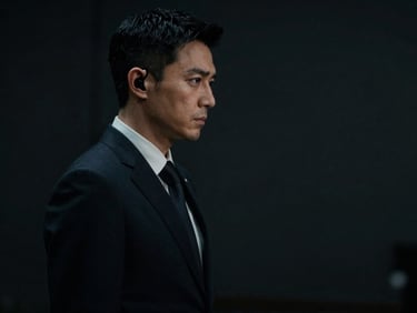 Clean-cut specialist in a dark tailored suit, earpiece visible, discreetly scanning a perimeter, low-key lighting.