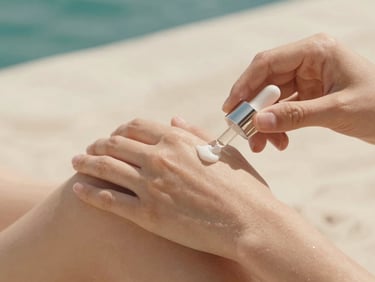 Hands gently applying a serum to healthy skin, with bright, diffused natural light. Focus on the texture of the skin and product, soft ivory tones.