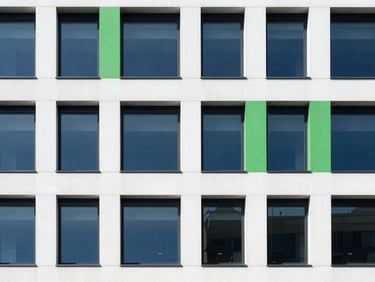 Minimalist architectural details of a modern office building, deep blue and crisp white tones, sharp green accents, clean natural light, 35mm.