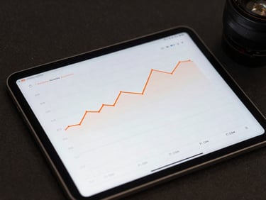 Close-up of a modern tablet displaying clean analytics graphs with orange lines, soft studio lighting, dark corporate background.