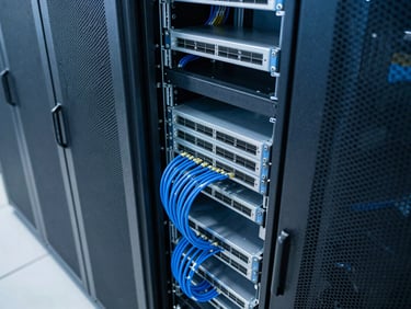 High-angle shot of a clean server room, network cables organized, cool blue lighting.