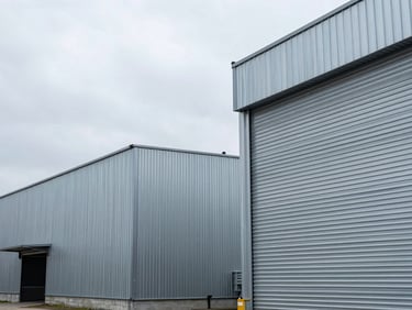 Orthogonal architectural view of a modern steel storage facility, cool overcast daylight, sharp metallic lines, clean industrial order.