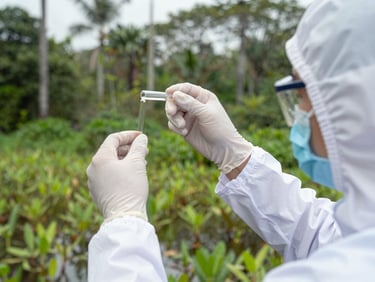 Close-up of a scientist in high-vis gear collecting water samples in a lush Malaysian wetland, crisp overcast daylight, sharp focus, 35mm