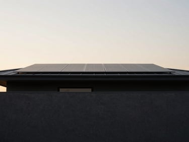 Minimalist modern home with a flat charcoal roofline integrated with flush solar panels, soft twilight lighting.