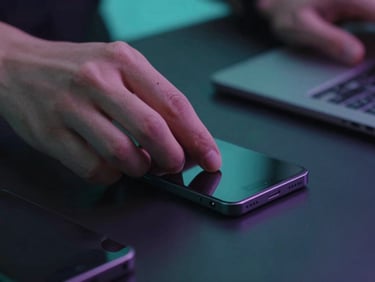 Close-up of hands organizing sleek modern gadgets on a clean dark surface, subtle cyan ambient lighting, shallow depth of field