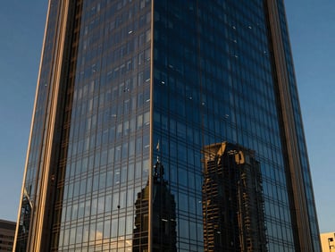 Architectural exterior of the Burjuman Business Centre in Dubai, modern glass facade reflecting blue sky.