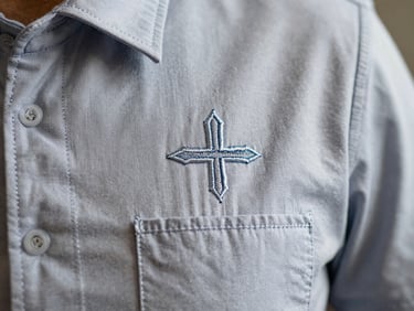 Close-up of precise embroidery on a heavy organic cotton corporate uniform, showing clean stitches and texture