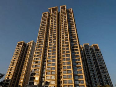 High-angle architectural exterior of DLF Privana West, a modern luxury high-rise in Gurugram, bathed in dramatic twilight golden-hour light, wide-angle lens, sharp focus, deep blues and warm gold accents