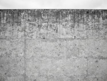 Straight-on architectural shot of a cured concrete wall showing perfect aggregate exposure and custom color-matching, overcast daylight, sharp detail