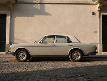 Clean lines of a vintage luxury collector vehicle parked on a quiet cobblestone street, dramatic architectural shadowing, warm muted tones