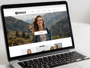 Close-up product shot of a laptop screen showing a polished small business website homepage with clean navigation, hero image, and call-to-action button visible, bright even studio lighting, slight three-quarter angle