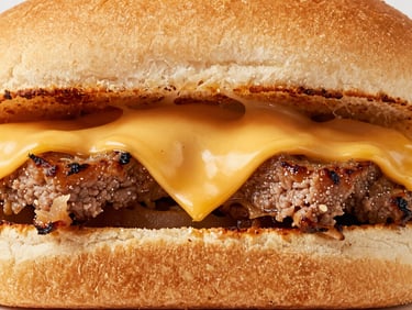 Macro close-up of a loaded philly steak sandwich with melted cheese pulling apart, bright studio light