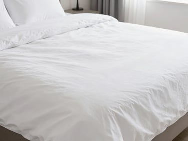 Freshly made bed with crisp white linens in a bright, modern Airbnb bedroom, a cleaner smoothing the duvet, high-key natural light, inviting and clean